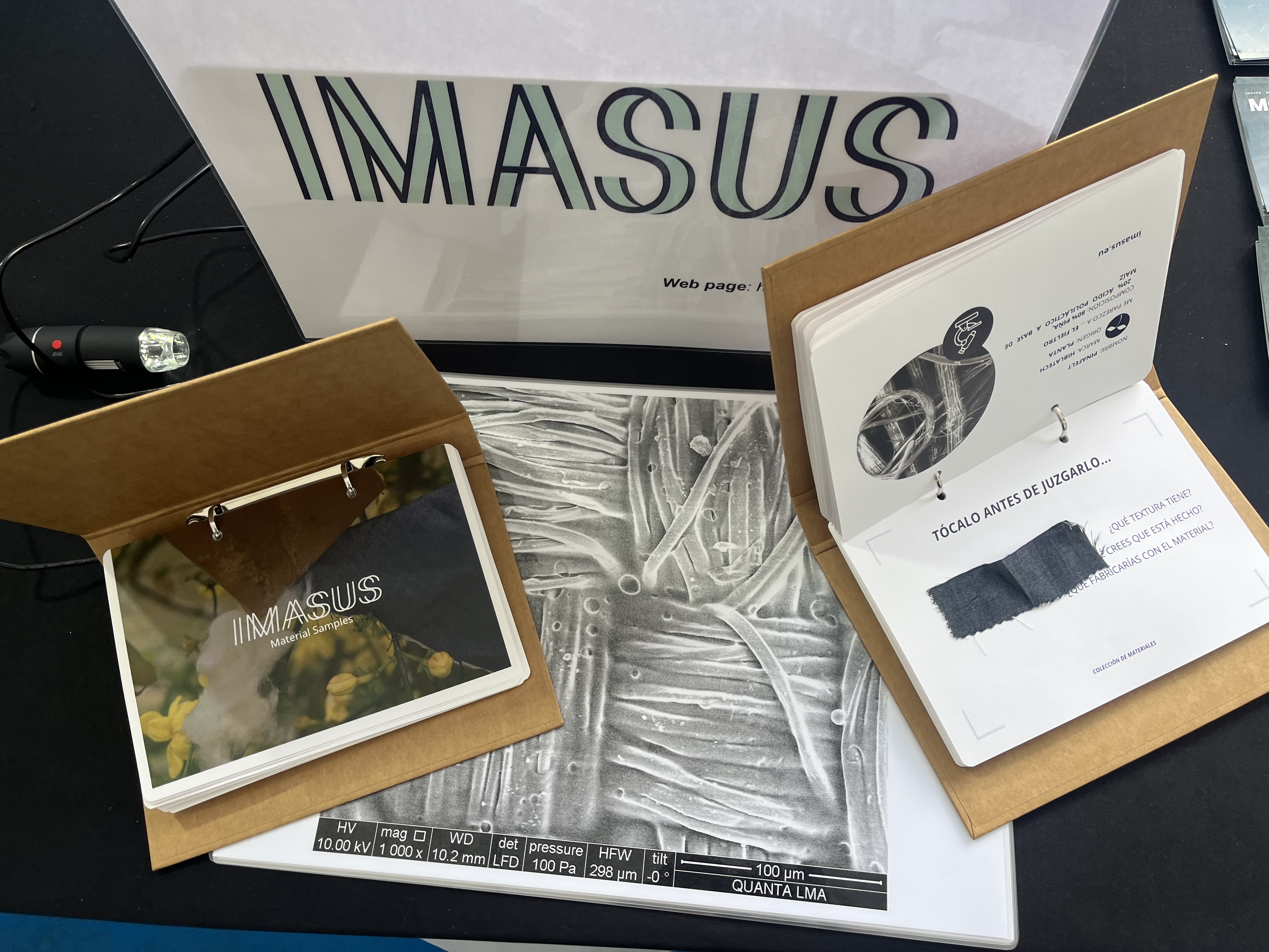 IMASUS material sample books and a digital magnifying glass at the stand